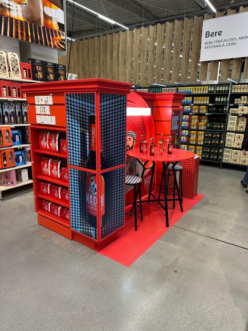 Stand promoțional Madri Excepcional cu decor de bar și scaune în stil spaniol, amplasat în zona de băuturi dintr-un supermarket.
